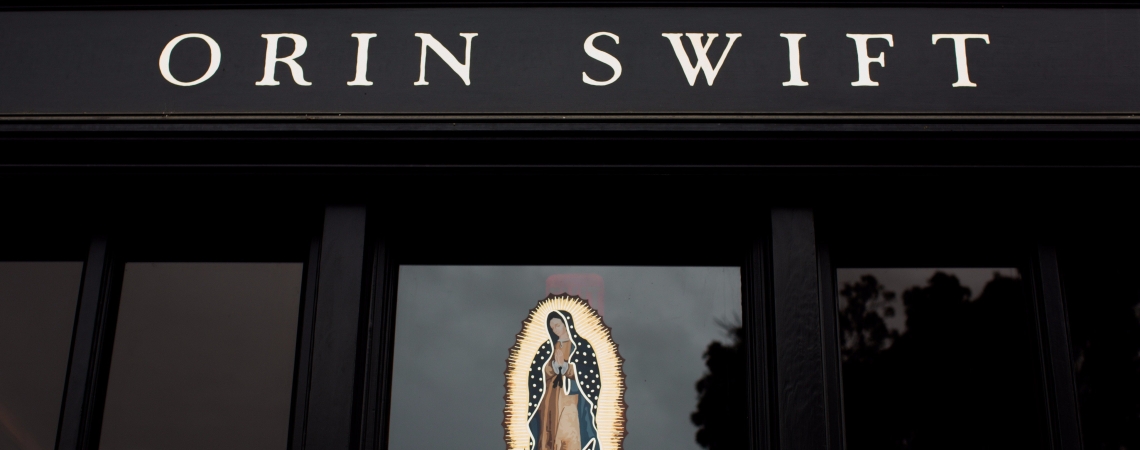 Schwarze Fassade mit religiösem Bild und elegantem Schriftzug.